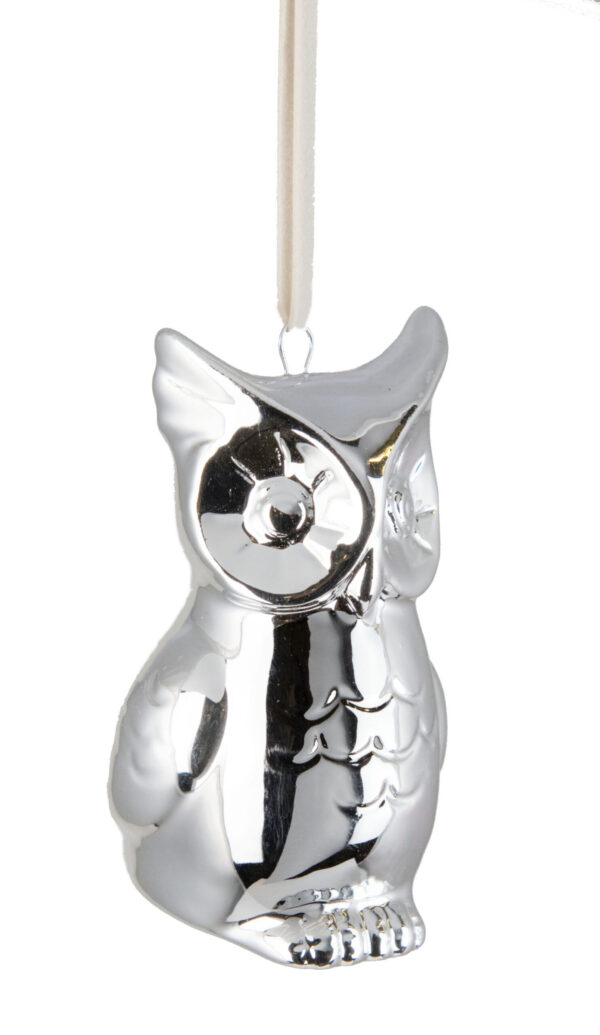 A silver owl ornament hanging on a white string.