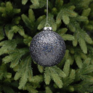 A silver Christmas bauble hanging from a pine tree.