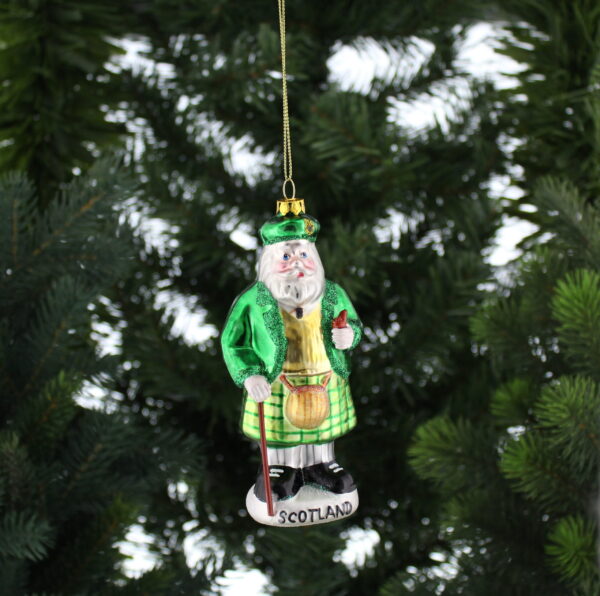 A Scottish Santa Claus ornament hanging on a tree.