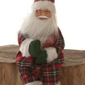 A 30cm Sitting Scottish Tartan Santa sitting on a stump.