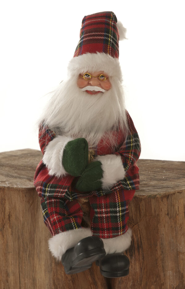 A 30cm Sitting Scottish Tartan Santa sitting on a stump.