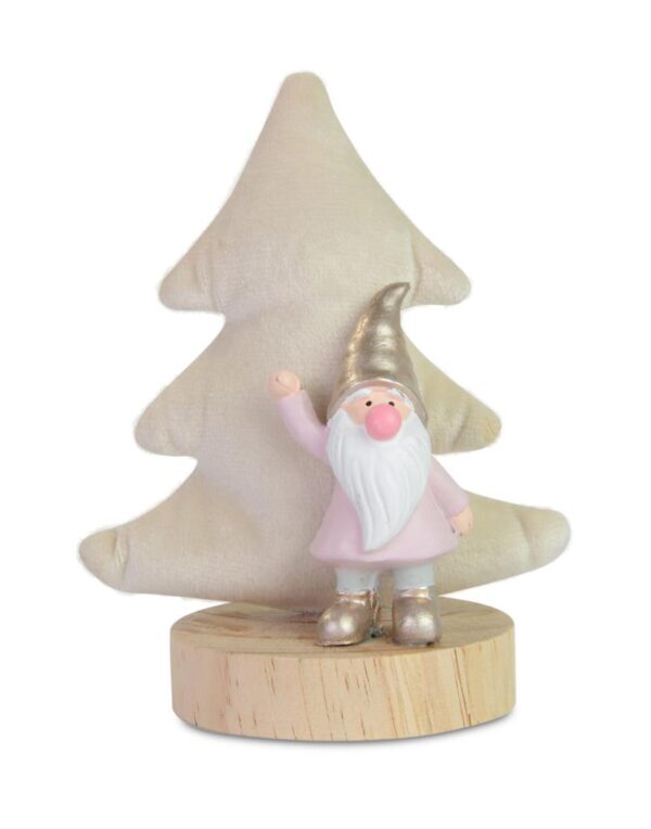 A waving poly resin gnome with pink coat and gold hat and boots stands in front on a cream coloured velour Christmas tree on a wooden plinth.