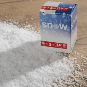 A box of fake snow is sitting on a wooden table.