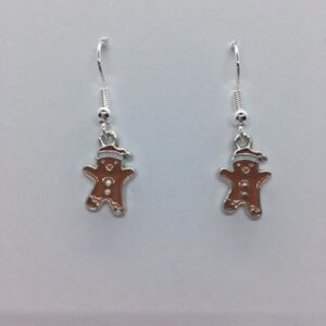 A pair of cute gingerbread men earrings with a santa hat on them.