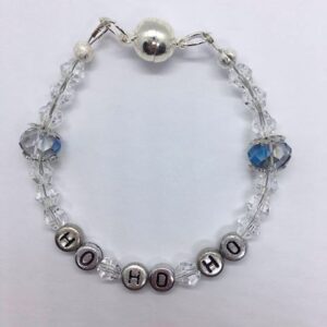 A Clear, sparkly, festive beaded bracelet with the phrase ho-ho-ho on it.