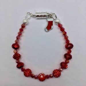 A festive red beaded bracelet with a silver charm.