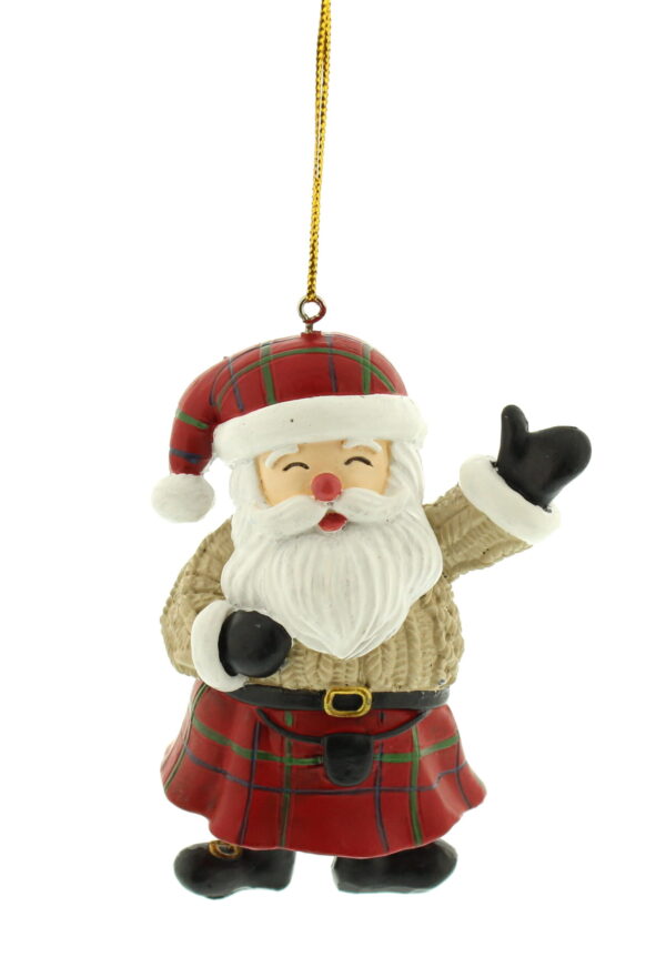 A polyresin Scottish Santa Christmas Tree Decoration. Santa wears a red tartan kilt complete with belt and sporran. He has matching tartan Santa hat with white trim. He wears a cream coloured cable knit jumper and black boots and gloves. He has a jolly face and is waving his left arm as a greeting. He hangs from a gold string.