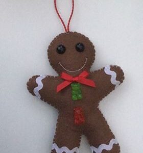 A handmade felt gingerbread man decoration with green and red gummy bear shaped buttons and a red bow.