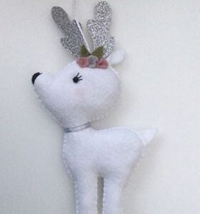 A handmade white felt reindeer ornament with sparkly silver antlers and collar with flower decoration.