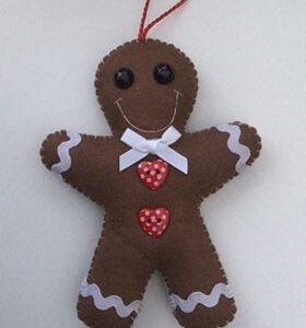 A handmade felt gingerbread man decoration with red heart shaped buttons and a white bow.