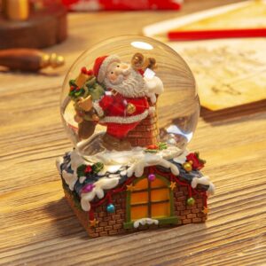 Hand Painted Santa in Chimney Snow Globe - 8.5cm This adorable Santa is ringing his golden bells with joy as he stands next to the chimney ready to deliver his sack full of gifts. Santa and the chimney are enclosed in a snow globe that's nestled onto the roof of a festively decorated house. When turned upside down gentle snow cascades over Santa.  This piece is hand painted and measures 8.5 x 7 x 7 cm