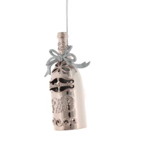 Pale pink/rose gold coloured plastic Champagne bottle Christmas tree decoration. the bottle feature cut away details and the word 'Celebrate' across the front, their is a motif of a bunch of grapes below the text, Around the neck is a silver plastic bow. It hangs from a silver string.