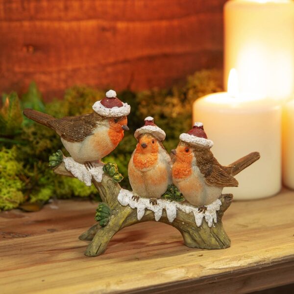 A ceramic figurine of Three Robins on a Branch. These jolly robins are all wearing traditonal Santa hats as they perch upon this snowy branch. They are decorated with a light dusting of gold glitter.