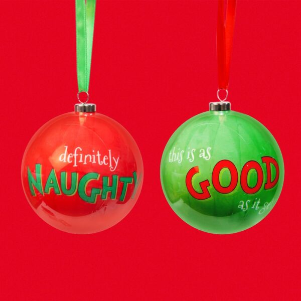 Two decoupage christmas tree baubles from 'The Grinch' collection. The bauble on the left is red and has text on it that reads 'definitely NAUGHTY', it hangs from a green ribbon. The bauble on the right is green and has text on it that reads 'this is as GOOD as it gets' and hangs from a red ribbon. Shown against a red background.