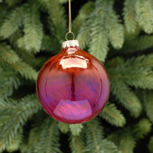 A red and pink ombre coloured, round glass Christmas tree bauble with a twist hanging from a gold string.