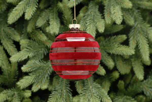 A clear glass bauble with burgundy flocked bands running horizontally around it from top to bottom, the flocked bands are sepearated by thin burgundy glitter lines. Hanging from a gold string.