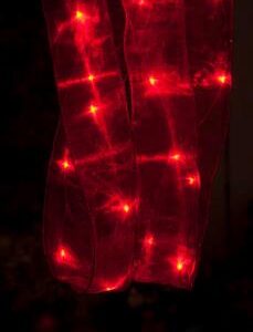 A LED-lit Festive Red Ribbon (2m) hanging in the dark.