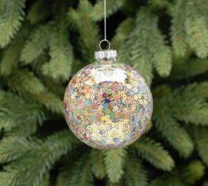 A clear glass Christmass tree bauble filled with pastel coloured rainbow sequins. hanging from a silver string.