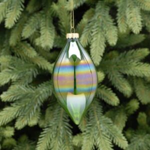 A translucent green iridescent olive drop shaped Christmas tree bauble hanging from a fir tree.