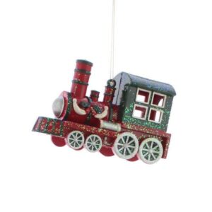 A christmas tree decoration in the shape of a train. The train is predominantly red in colour with a dark green cabin and silver wheels. The funnel, engine and front of the train are detailed in dark green. On the side of the engine is a sprig of holly with a red bow flanked by two silver swags. The whole train is covered in iridescent glitter. It hangs from a gold string.