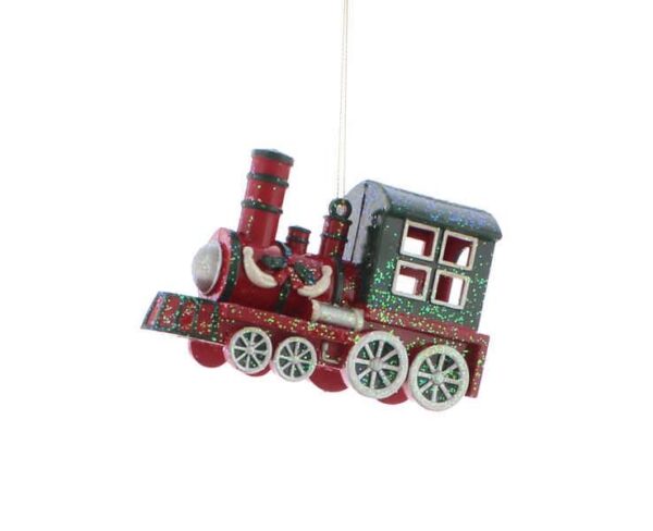 A christmas tree decoration in the shape of a train. The train is predominantly red in colour with a dark green cabin and silver wheels. The funnel, engine and front of the train are detailed in dark green. On the side of the engine is a sprig of holly with a red bow flanked by two silver swags. The whole train is covered in iridescent glitter. It hangs from a gold string.