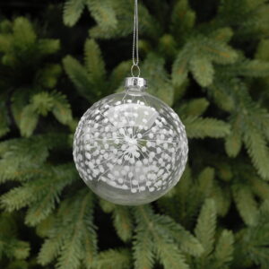 A round, clear glass Christmas tree bauble decorated with white starbursts all around it, hanging from a silver string.