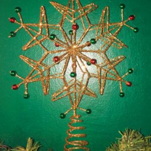 A wire frame Christmas tree topper in the shape of a six ointed snowflake. the wire frame is covered completly in gold glitter and has red and green bead on its tips and sround the centre. The snowflake sits on a conical spring for mounting on the tree.