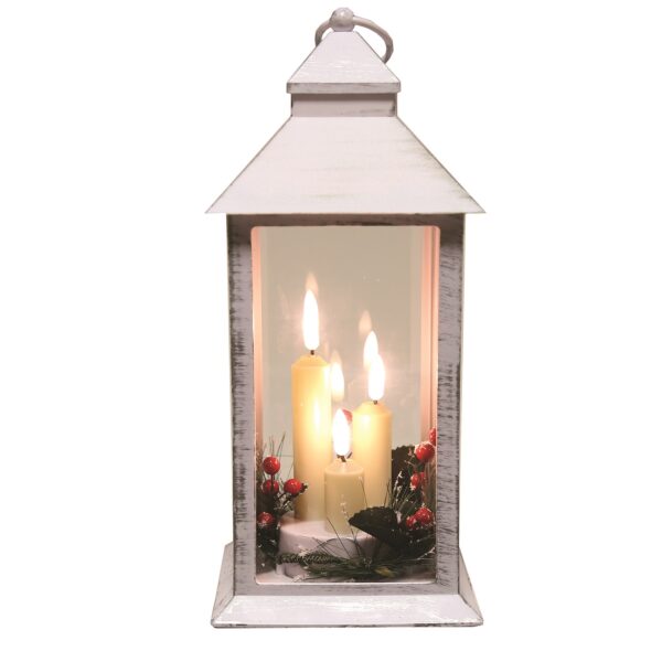 A 31cm White Deco LED Lantern with three LED lit faux candles surrounded with sprigs of festive foliage and red berries.