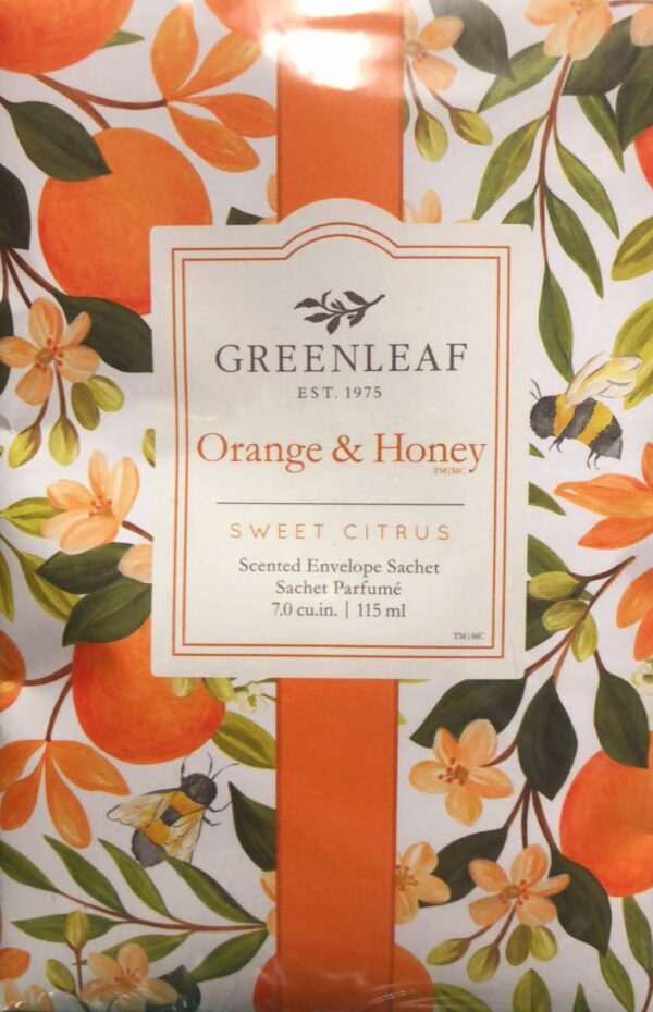 An Orange & Honey fragranced scent sachet showing a painted image of an orange tree with ripe oranges, orange blossom, green leaves and honey bees. An orange band runs vertivally down the middle of the image and on top of the band sits a cream coloured box. At the top of the box in black is the logo for the Greenleaf Company and beneath that in orange is text that reads 'Orange & Honey™ SWEET CITRUS' and in black beneath that 'Scented Envelope Sachet Sachet Parfume 7.0CU.IM. 115ML'.