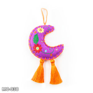 A purple felt, crescent moon shaped Christmas tree decoration. This purple felt moon has a red and yellow flowers and a green leaf embroidered in the centre and orange stitching around the outside. At the top there is a loop of orange wool for hanging and two orange tassels hangs from the base of the moon.