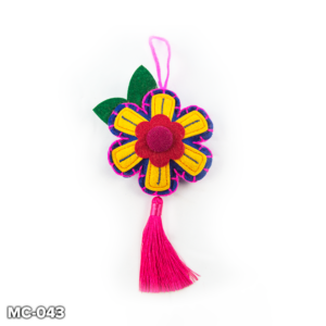 A blue felt, flower shaped Christmas tree decoration. This blue felt flower has a yellow petals with a red and purple centre. It has pink stitching around the outside. At the top there is a loop of pink wool for hanging and two green felt leaves. A pink tassle hangs from the bottom petal of the flower.