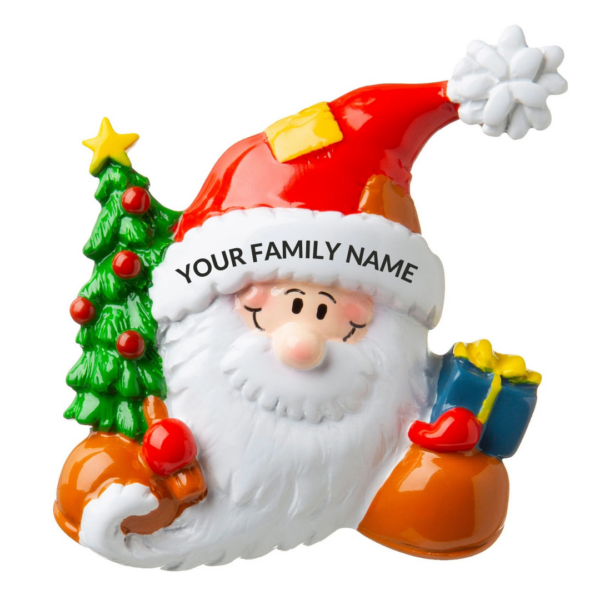 A polyresin Personalisable Christmas tree decoration in the shape of a Santa's head. Santa is holding a green Christmas tree decorated with red baubles and a yellow star and a blue gift with a yellow ribbon He is wearing his Santa hat and on the white trim of the hat there is black text that says 'YOUR FAMILY NAME' implying the decoration can be personalised.