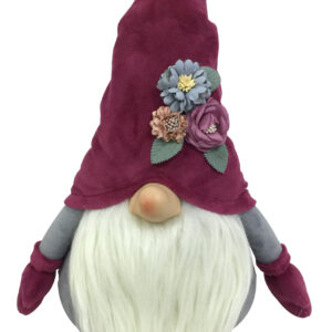 A burgundy coloured Christmas Gonk with flowers. The body of this gonk is grey with burgiundy coloured mittens at the end of each arm. It has a fluffy cream coloured beard which sits beneath its pink nose. On it's head it has a pointy burgundy hat that has a small posy of blue, purple and pink flowers with green leaves that sits above the nose on the left hand side.