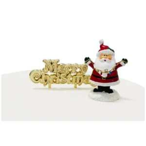 A polyresin Santa Claus cake topper. Santa is wearing his traditional red outfit and is holding a string of fairy lights between his open arms. He is standing in a mound of snow next to a gold plastic Merry Christmas motto cake decoration.