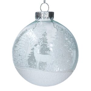 A clear glass ornament decorated with a white winter scene featuring a majestic stag in a snowy forest with accents of white iridescent glitter.