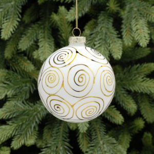 A white glass Christmas tree bauble decorated with metallic gold swirls all over. hanging from a gold string.