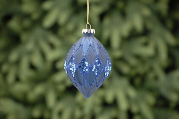 A matt navy, geometric egg shaped, glass Christmas tree bauble decorated with fine lines of blue glitter and blue glitter and sequin diamond shaped panels.