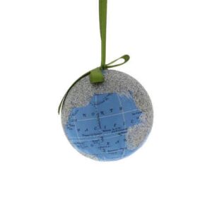 A decoupage Christmas tree bauble depicting the planet earth. The land masses have been covered in silver glitter and only the blue of the oceans can be seen along with latitude and longitude lines and the names of the oceans. Hanging from a green ribbon.