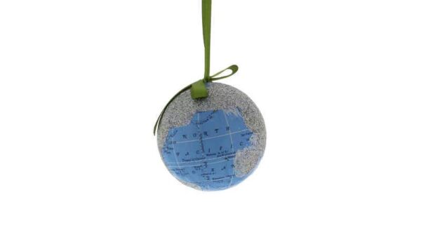 A decoupage Christmas tree bauble depicting the planet earth. The land masses have been covered in silver glitter and only the blue of the oceans can be seen along with latitude and longitude lines and the names of the oceans. Hanging from a green ribbon.