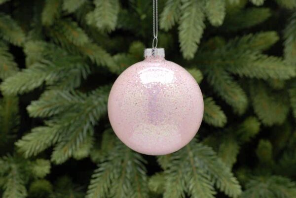 A clear glass Christmas tree bauble filled with iridescent sparkly pink glitter. Hanging from a silver string.