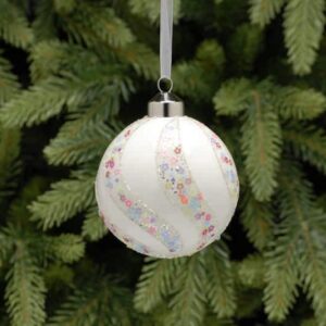 Matt White Glass Christmas Bauble with Colourful Star Swirl Pattern with Christmas tree background.