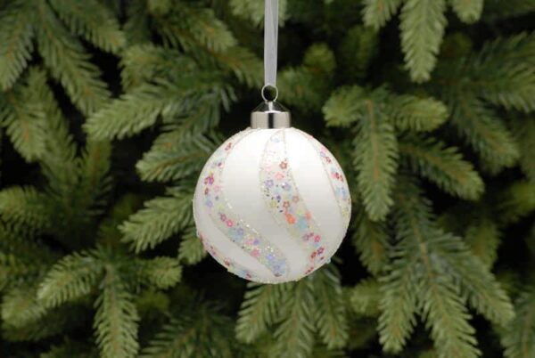 Matt White Glass Christmas Bauble with Colourful Star Swirl Pattern with Christmas tree background.