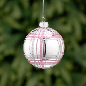 A metallic silver, glass Christmas tree bauble decorated with fine horizontal and vertical lines of pale pink and silver glitter depicting a tartan pattern.