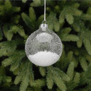 A clear, ice textured, glass Christmas tree bauble filled with fake snow. Hanging from a white ribbon.