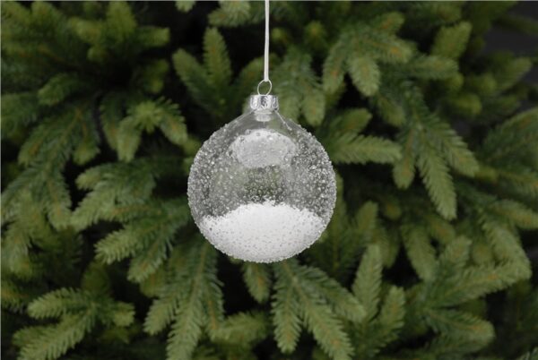 A clear, ice textured, glass Christmas tree bauble filled with fake snow. Hanging from a white ribbon.