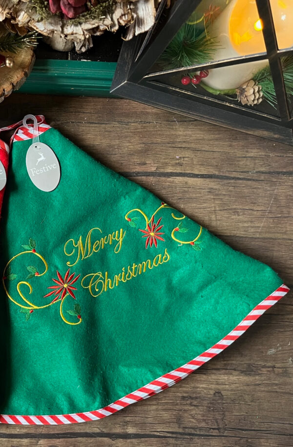 80cm Embroidered green Felt Tree Skirt with a decorative Merry Christmas message and decorative swirl in gold & holly and starburst embroidery. Trimmed with red and white candy cane style fabric.