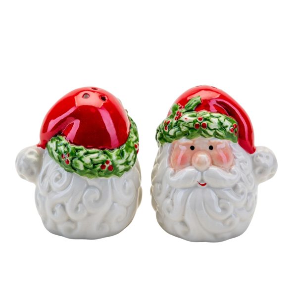 A set of ceramic Santa Head Salt and Pepper Shakers. Santa has a cheerful face with rosy cheeks surrounded by a white curly beard. His red Santa hat has a trim of green holly leaves with red berries and a white pompom. The hats have holes for shaking out the condiments.