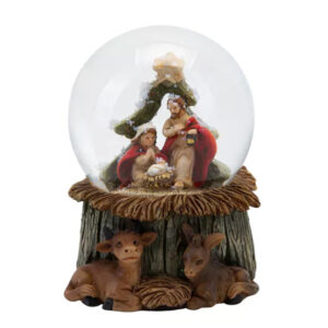 The Hand Painted Nativity Scene Snowglobe features a depiction of Mary, Joseph, and baby Jesus inside, with a cow and donkey at the base.