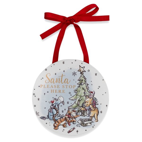 Disney Winnie Hanging Plaque featuring a colourful drawing of Pooh, Piglet, Tigger and Eyeore decorating a Christmas tree. It has gold text that reads "Santa Please Stop Here" and hangs from a red ribbon.