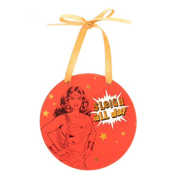 A red DC Comics Wonder Woman Hanging Plaque featuring a drawing of Wonder Woman surrounded by gold stars. It has gold text that reads "Sleigh All Day" and hangs from a gold ribbon.